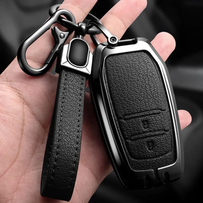 Keyvane armor key fob cover in jet black with leather keychain, held in hand